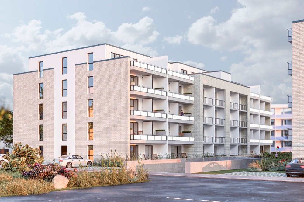Außenansicht der Neubau-Wohnanlage in Damp mit begrünten Außenflächen